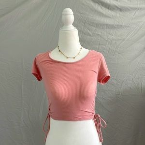 Pink stretchy shirt, with adjustable ties for the length.